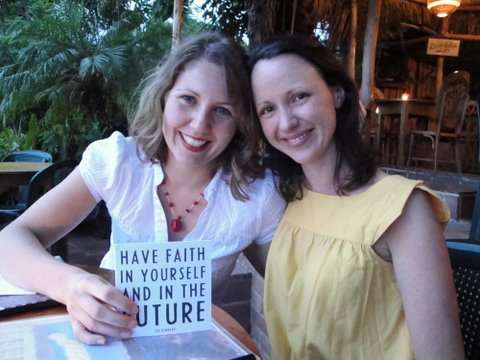 Two women close to each other, showing a card into the camera