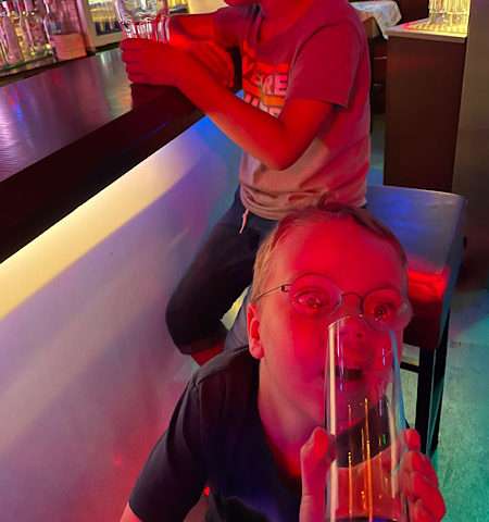 Little boy drinking coke at a bar