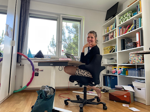 Woman sitting at her office desk, laughing into the camera