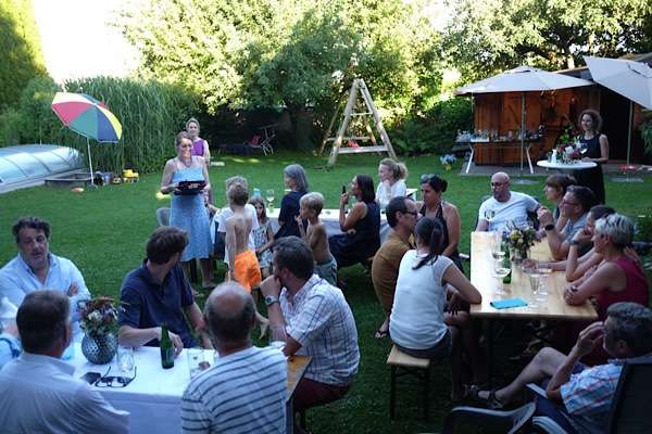 People sitting on benches, celebrating in a garden