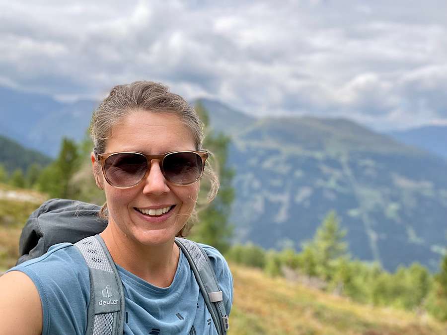 Woman with sunglasses taking a selfie in the mountains