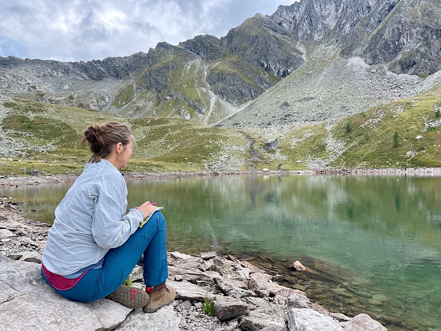 Woman sitting and overlooking a mountain lake