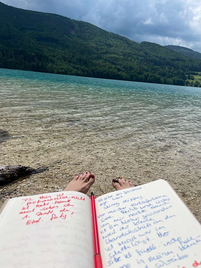 Writing in notebook at the lake