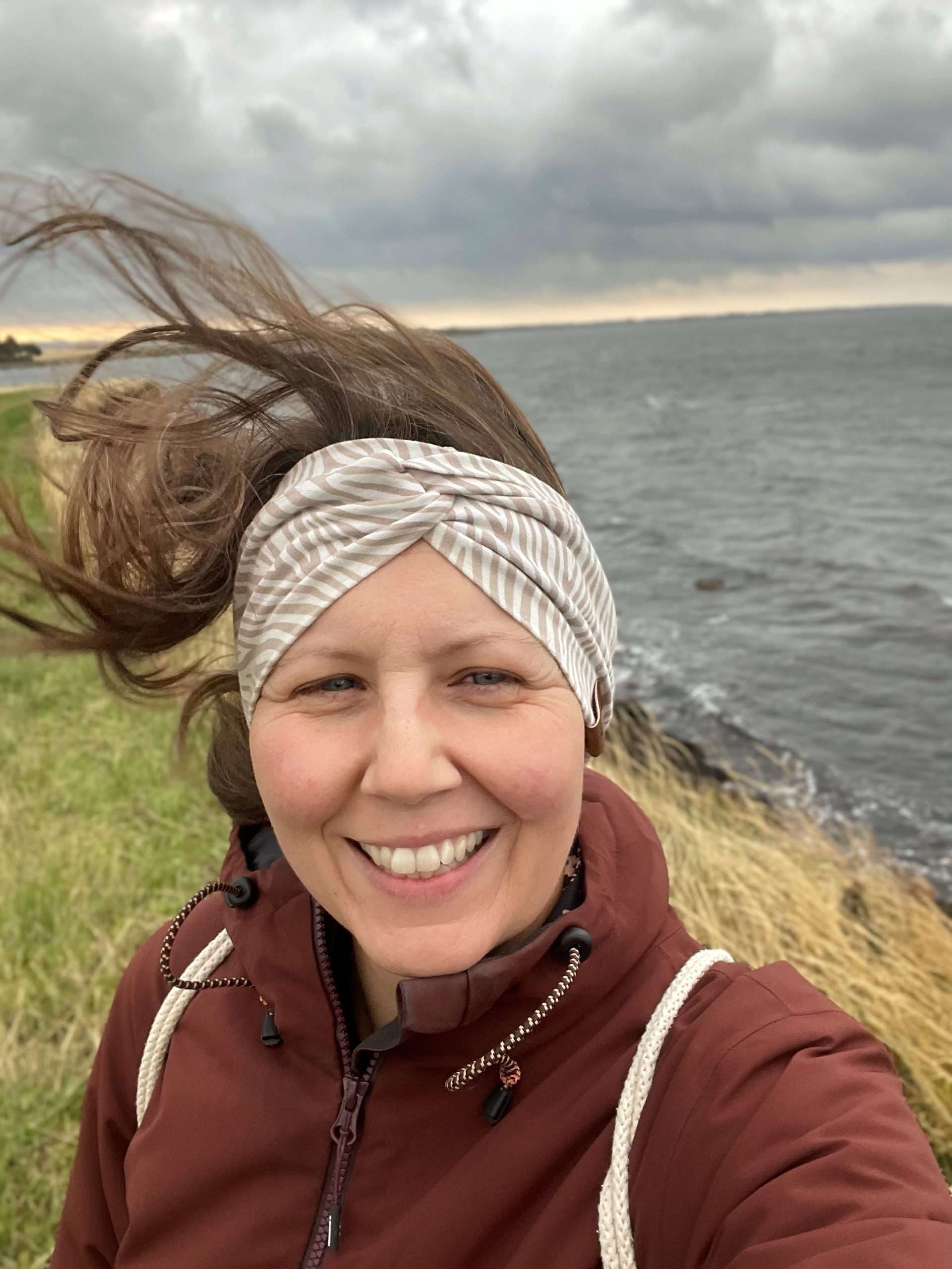 Woman with flying hair standing in the wind at the Baltic Sea