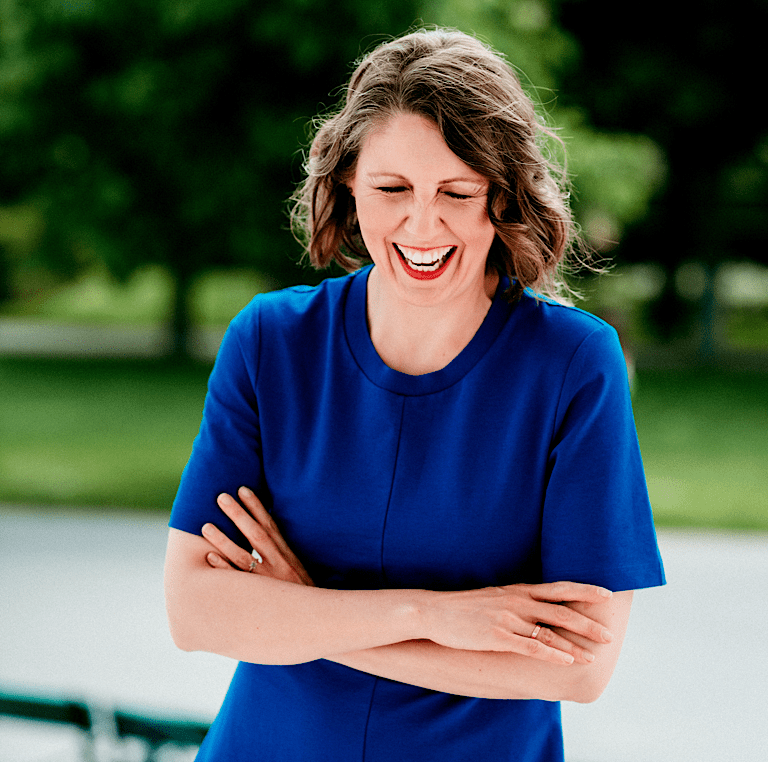 Woman in blue dress laughing heartily